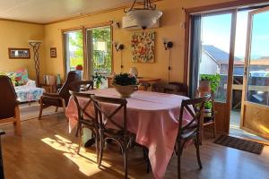 a dining room with a table with a pink table cloth at Comfortable house with balcony&Terrace and view in Kopervik +22 photos