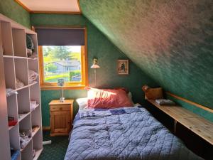 a bedroom with a bed and a green wall at Comfortable house with balcony&Terrace and view in Kopervik