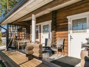 una cabina in legno con portico con sedie e tavolo di Holiday Home Valkjärvi 2 by Interhome a Mankala