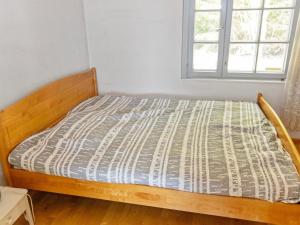 Cette chambre comprend un lit avec un cadre en bois et une fenêtre. dans l'établissement Holiday Home Heinlahti by Interhome, à Rautjärvi