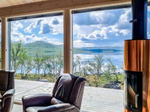a living room with two chairs and a large window at Holiday Home Loimu by Interhome in Kilpisjärvi