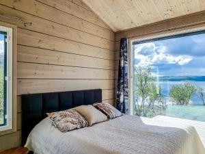 a bedroom with a bed and a large window at Holiday Home Loimu by Interhome in Kilpisjärvi +14 photos