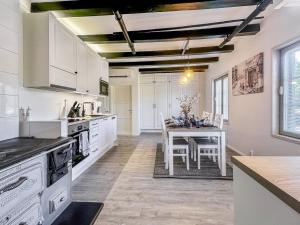 a kitchen with white cabinets and a table with chairs at Holiday Home Holiday pleikilä by Interhome in Kustavi