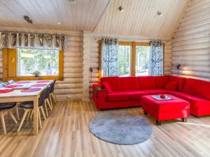 ein Wohnzimmer mit einem roten Sofa und einem Tisch in der Unterkunft Holiday Home Rukanlyhty by Interhome in Rukatunturi 