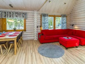 ein Wohnzimmer mit einem roten Sofa und einem Tisch in der Unterkunft Holiday Home Rukanlyhty by Interhome in Rukatunturi 