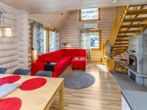 ein Wohnzimmer mit einem roten Sofa und einem Kamin in der Unterkunft Holiday Home Rukanlyhty by Interhome in Rukatunturi 