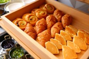 a wooden box filled with croissants and other pastries at Almont Inn Shonan Fujisawa in Fujisawa