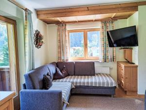 a living room with a couch and a flat screen tv at Apartment Hermine by Interhome in Auffach
