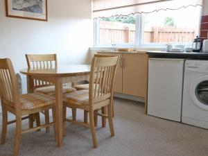 cocina con mesa, sillas y lavadora en Holiday Home Glamaig by Interhome, en Portree