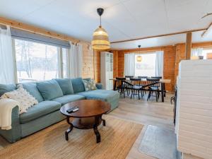 un salon avec un canapé bleu et une table dans l'établissement Holiday Home Brofeldt by Interhome, à Tohmajärvi