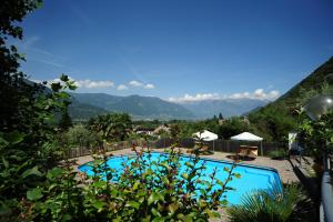 a swimming pool with mountains in the background at Pension Sonnheim in Gargazzone