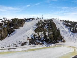 einen schneebedeckten Hügel mit Bäumen und einem Skilift in der Unterkunft Holiday Home Casa krogerus ruka by Interhome in Rukatunturi 