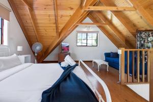 una camera da letto con un letto grande e un soffitto in legno di Muwarra Cottage Malua Bay a Malua Bay