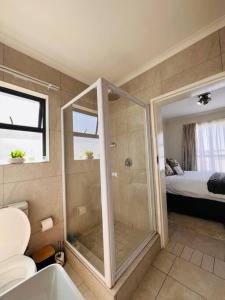 a bathroom with a shower with a toilet and a bed at Tetani's Luxury Oasis in Lakeside +29 photos