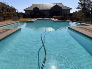 a swimming pool with a hose in the water at Tetani's Luxury Oasis in Lakeside