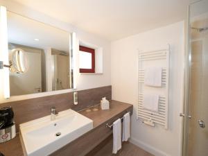 a bathroom with a sink and a mirror at Apartment Beech Resort Plauer See by Interhome in Ganzlin +15 photos