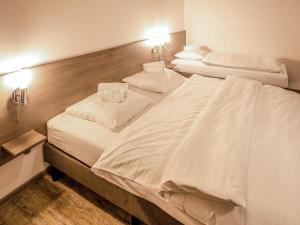 two beds in a hotel room with white sheets at Holiday Home Residence Lipno-9 by Interhome in Lipno nad Vltavou