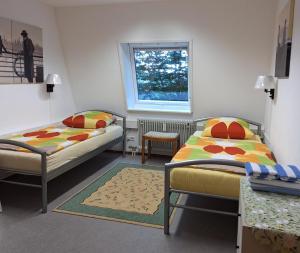 a room with two beds and a window at Pension beim Kastell in Sulz am Neckar