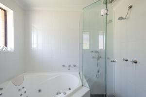 a white bathroom with a tub and a shower at Dream View Steps from the Beach in Sydney +29 photos