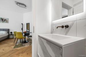 a white bathroom with a sink and a chair at easy-flat Rokitanskygasse - Apartments near Tram 43 to City Center in Vienna +163 photos