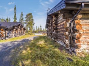 ein Blockhaus mit einem Holzstapel an der Seite in der Unterkunft Holiday Home Kelokanerva by Interhome in Rukatunturi 