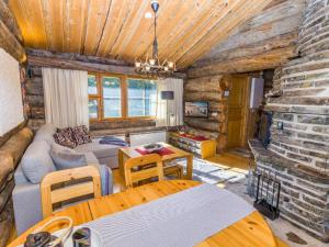 ein Blockhaus-Wohnzimmer mit Couch und Kamin in der Unterkunft Holiday Home Kelokanerva by Interhome in Rukatunturi 