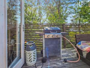 un gril posé sur une terrasse à côté d'une fenêtre dans l'établissement Holiday Home Kottage by Interhome, à Littoinen