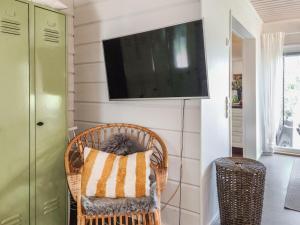un fauteuil en osier avec un coussin et une télévision accrochée au mur dans l'établissement Holiday Home Kottage by Interhome, à Littoinen