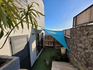 una casa con un patio verde al lado de un edificio en Leu Repère - Location de Charme, en Saint-Leu