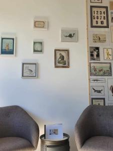 Dos sillas en una habitación con fotos en la pared en Leu Repère - Location de Charme, en Saint-Leu