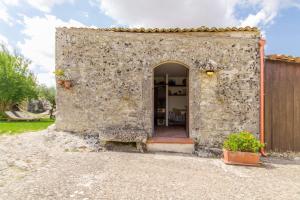 a stone wall with an entrance to a house at Santolìo Country Retreat - Relax in Masseria Siciliana con Giardino e Vista in Palazzolo Acreide