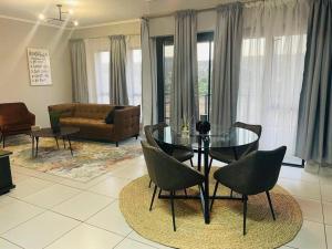 a living room with a glass table and chairs at Apparent Self Catering in Boschrand