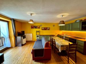 a kitchen with a table and a dining room at Brici's House 69 - Mountain Apartment Tonale in Passo del Tonale