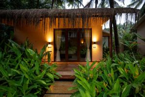 a small house with a thatch roof at Palma Beach Resort in Mandrem