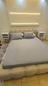 a large bed in a room with two tables at شقة فاخرة لعائلة بالمهندسين in Cairo