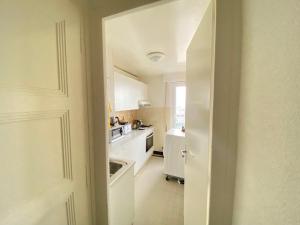 a kitchen with white cabinets and a white appliances at Studio charmant centré à Lausanne in Lausanne