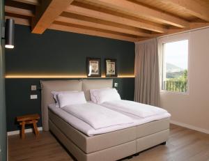 a bedroom with a bed in a room with a window at GardaZen Suites - luxury - adults only in Caprino Veronese +35 photos