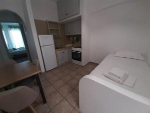 a small kitchen with a white bed in a room at ΚΥΘΝΟΣ ΡΟΜΑΝΤΖΑ δωματιο 5 in Mérikhas