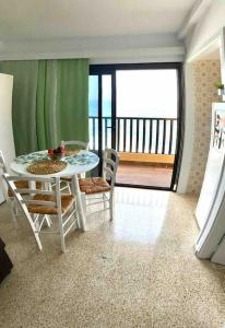 ein Esszimmer mit einem Tisch und Stühlen sowie einem Balkon in der Unterkunft Precioso apto vistas panorámicas Océano Atlántico in Las Galletas