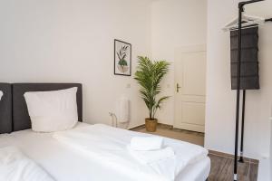 a bedroom with a white bed and a plant at LUXURY at Rosenthaler Platz in Berlin