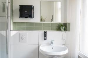 a bathroom with a sink and a tv on the wall at LUXURY at Rosenthaler Platz in Berlin