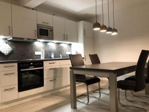 een keuken met een eettafel en stoelen bij Beach apartment Prora Captain in Prora