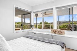 a bedroom with a bed and large windows at Sensational Ocean Views In Maianbar in Maianbar