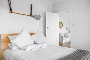 a white bedroom with a bed with white pillows at Sensational Ocean Views In Maianbar in Maianbar