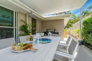a white table and chairs on a patio at Oscar's Broulee Beach Luxury Coastal Living in Broulee