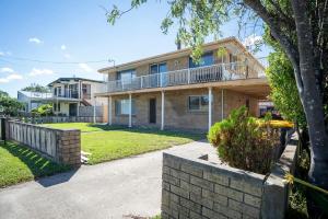 ein Backsteinhaus mit einem Balkon und einem Hof in der Unterkunft Rosa Beach Studio Getaway in Vincentia