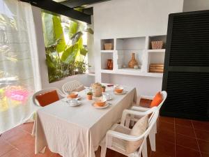 Un comedor con una mesa y sillas blancas. en Casa Buenos Aires, en Punta Grossa