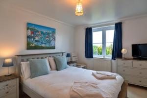 Un dormitorio con una cama y un televisor y una ventana. en Finest Retreats - Blue Horizon, en St Ives