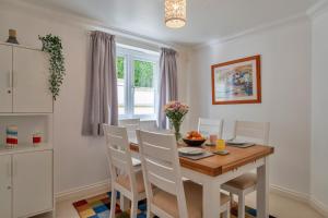 Una cocina y un comedor con mesa y sillas de madera. en Finest Retreats - Blue Horizon, en St Ives