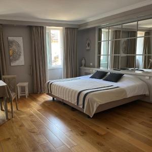 a bedroom with a large bed and a wooden floor at LE SOLEIL D'OR in Joinville